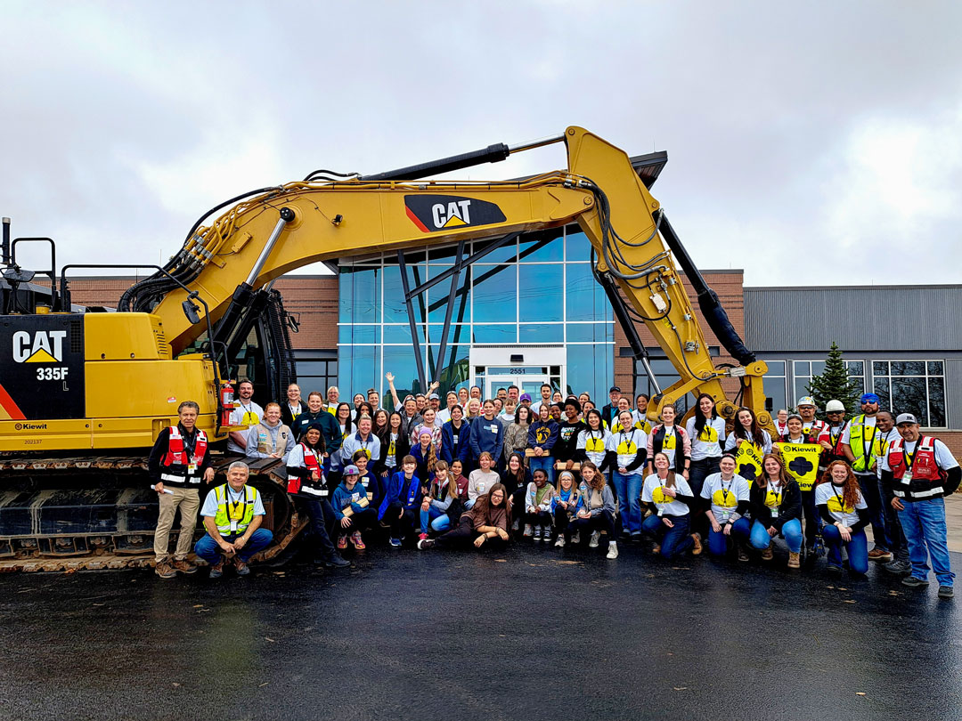 Build Like a Girl participants and volunteers posed in front of an excavator