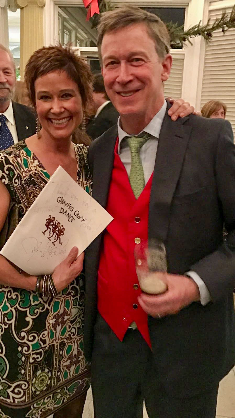 Two attendees holding a signed copy of Giraffes Can't Dance at a One Book One Denver event